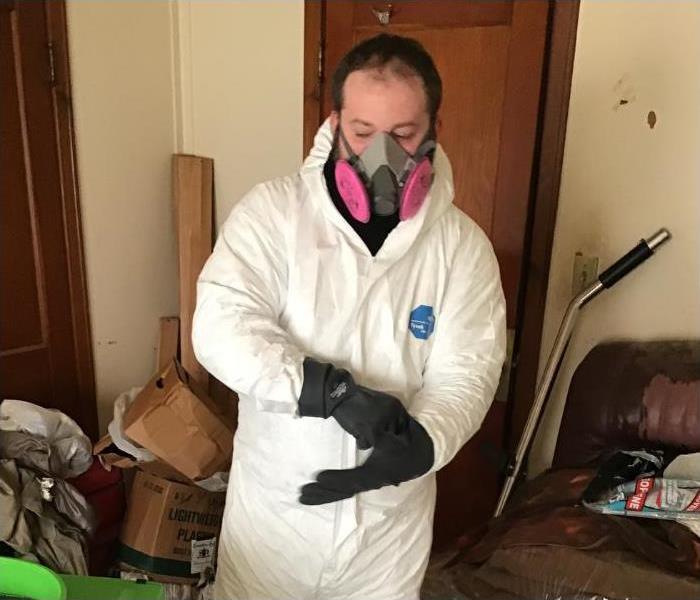 An employee in PPE wearing a mask